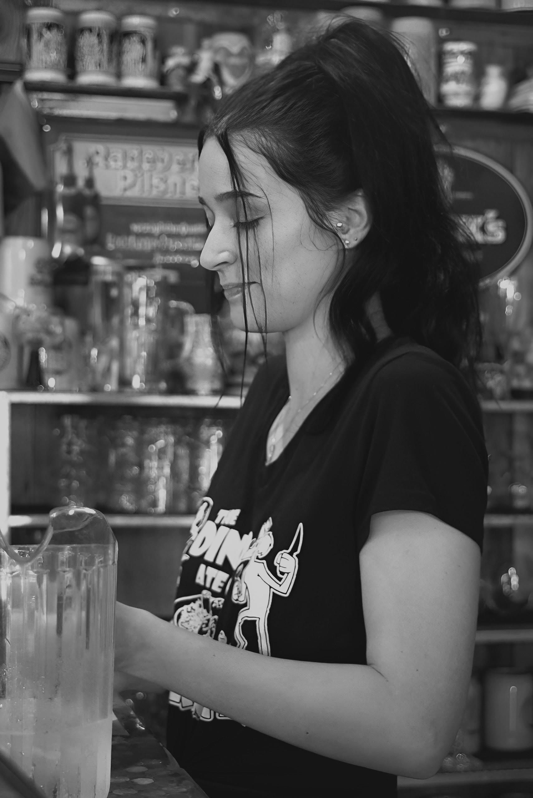 Black and White Photo of a Woman Standing behind the Counter at a Bar ...