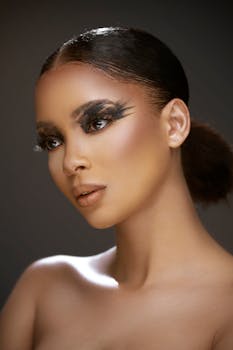 Close-up portrait of a model with bold eye makeup and flawless complexion.