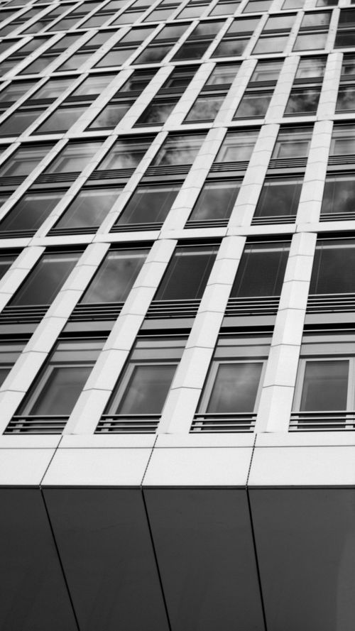 Free A low-angle view of a modern office building's facade in black and white. Stock Photo