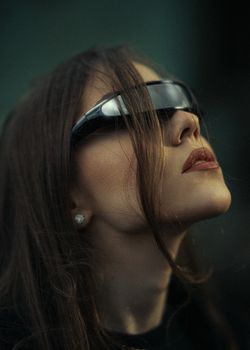 Close-up portrait of a woman wearing futuristic sunglasses, depicting a modern technological theme.