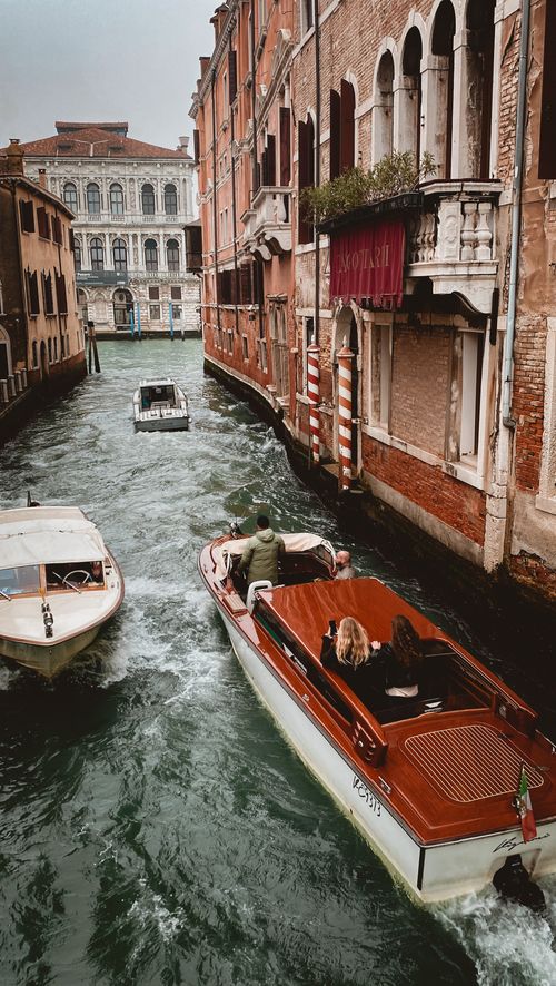 Free Scenic view of a Venice canal with boats navigating between classic architecture. Stock Photo