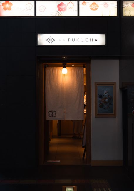 Warmly lit entrance with Japanese curtain in Kyoto, Japan