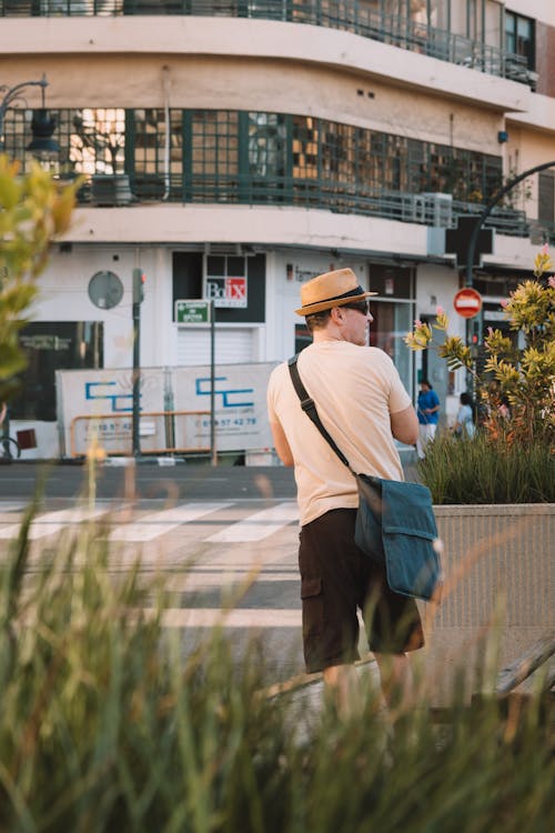 Man in Hat and with Bag Standing near Street