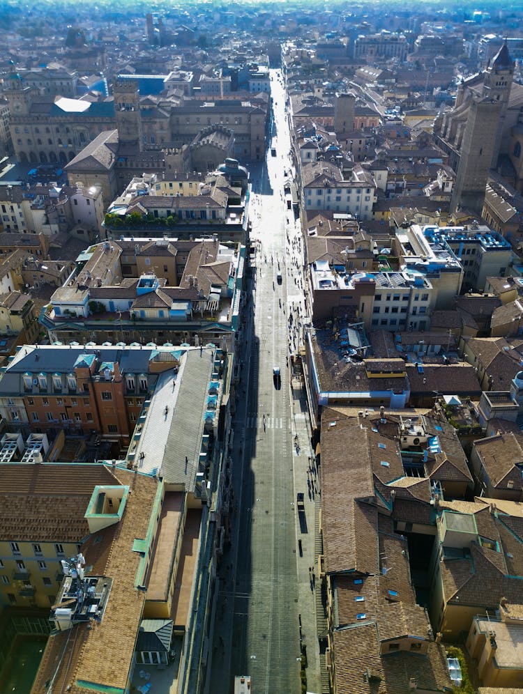 Cars Driving On Road In City With Old Buildings