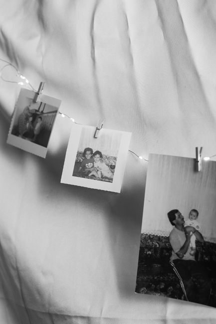 Vintage black and white family photos hung with string lights for a nostalgic feel.