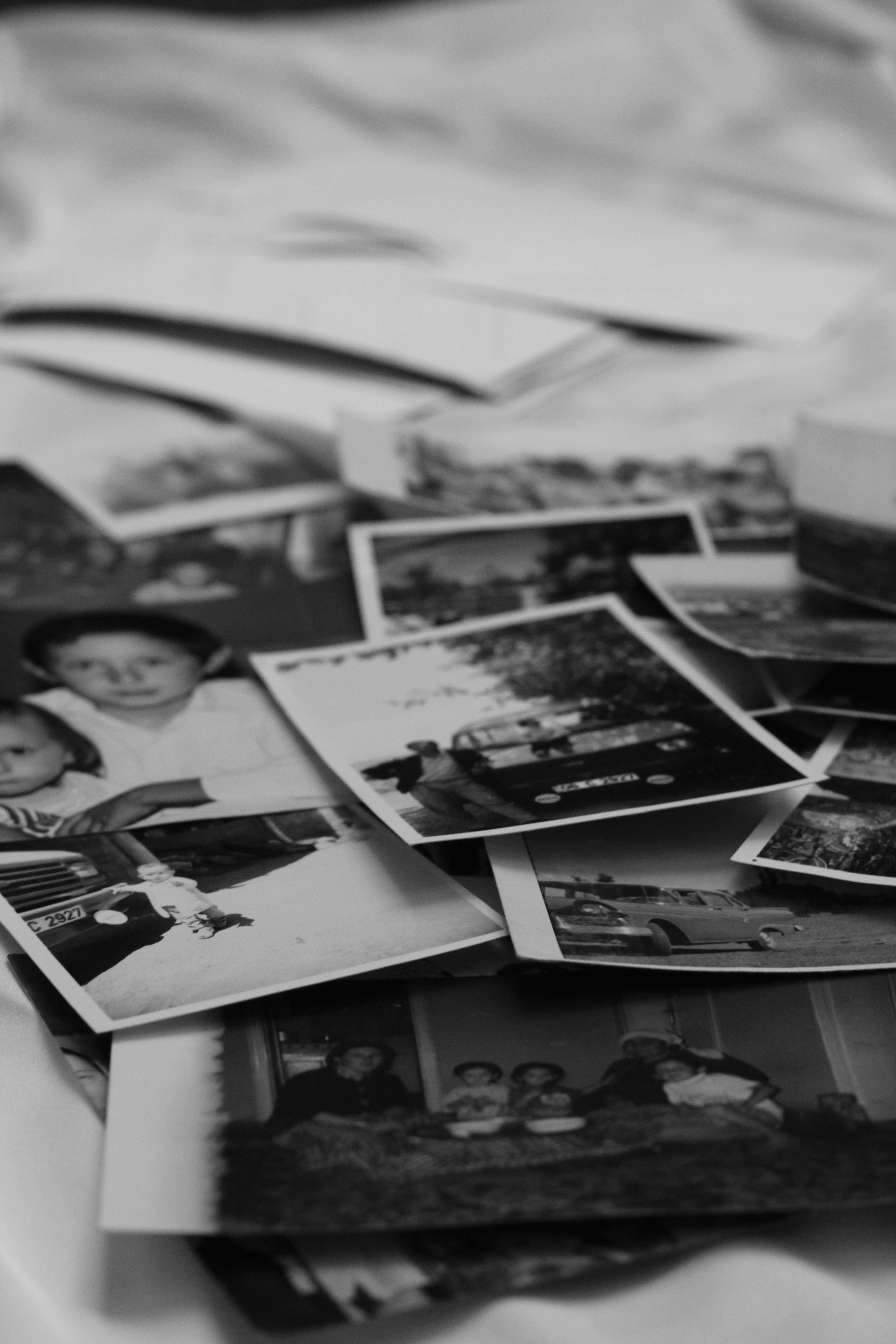 A nostalgic collection of vintage black and white photographs piled together.