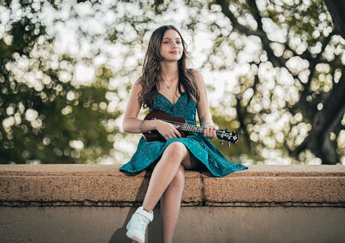Woman in Green Dress Sitting with Guitar