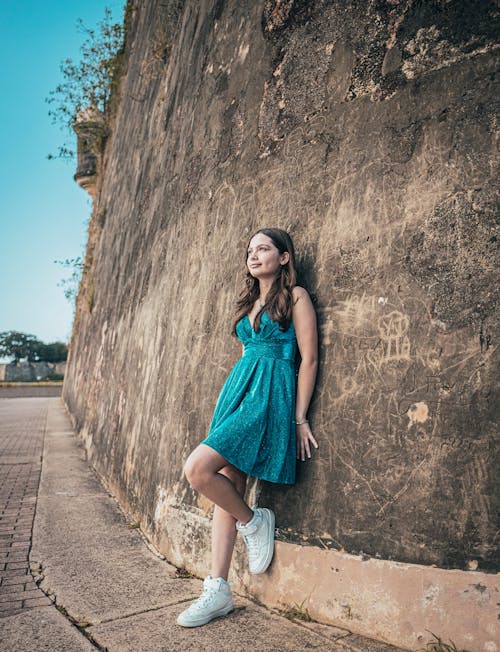 Woman in Sundrss Standing by Wall