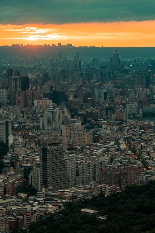 Free A breathtaking aerial view of a modern cityscape at sunset, showcasing towering skyscrapers and dense urban architecture. Stock Photo