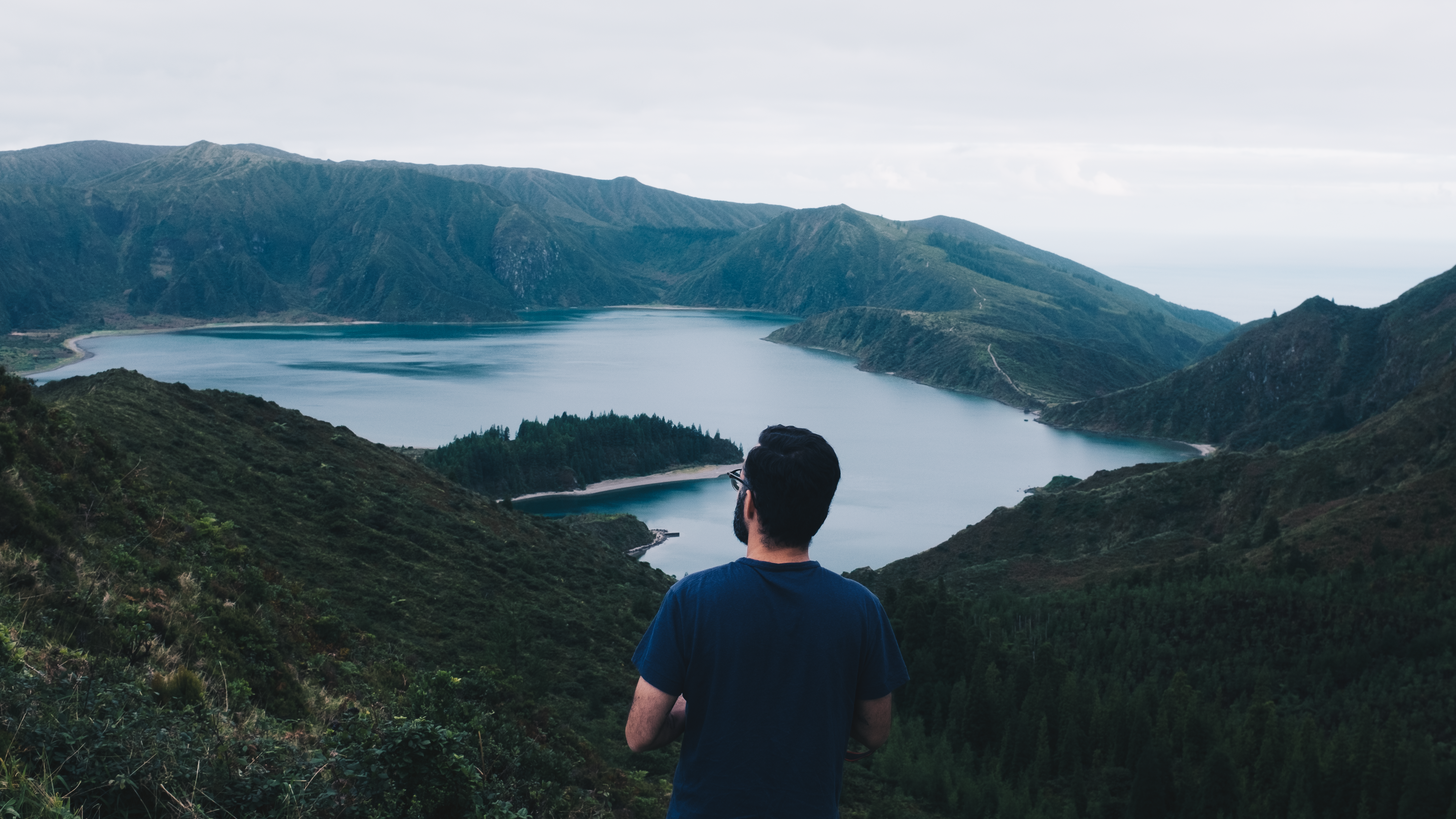 A Man Standing on a Hill with the View of a a Lake · Free Stock Photo