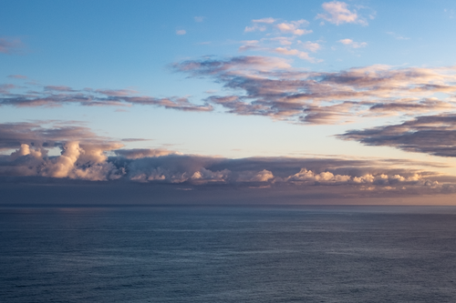 Free Peaceful ocean view with stunning clouds and dramatic sky at sunset. Stock Photo