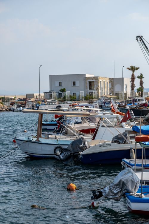Free Small boats moored in the tranquil harbor of Yenifoca, İzmir, Türkiye under a clear sky. Stock Photo
