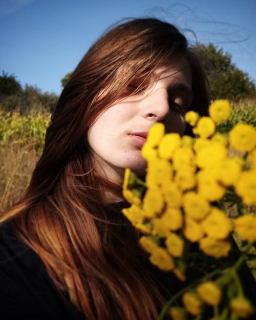 Young Woman Holding a Bouquet of Yellow Flowers