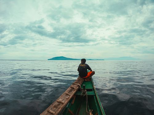 Free A serene scene of a man fishing on a traditional boat in Batangas, Philippines. Stock Photo