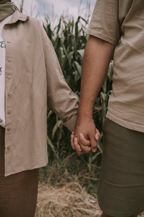 Close-up of People Holding Hands on a Field 