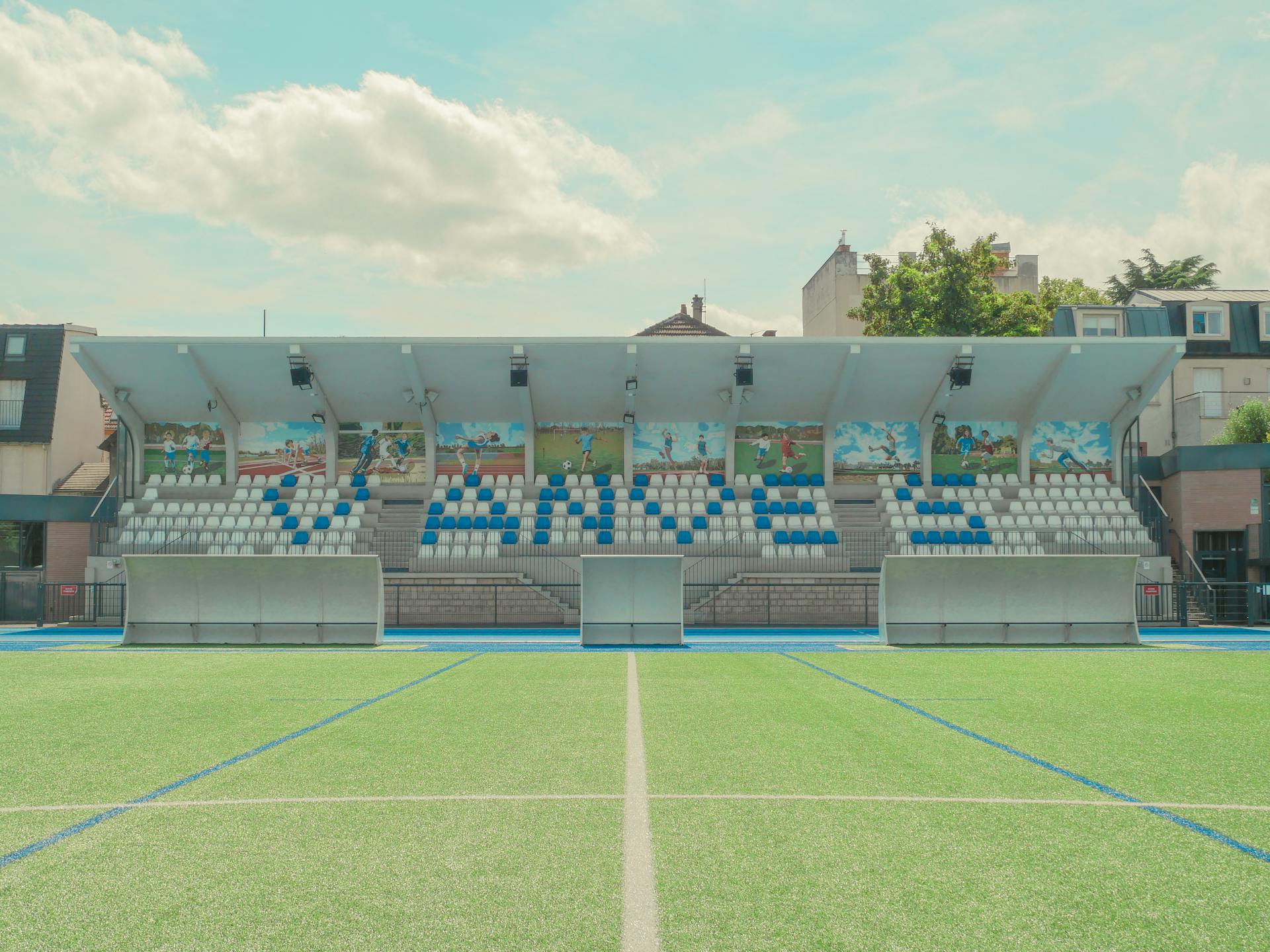 A vibrant tennis stadium in Vanves, France, with colorful seating and murals.