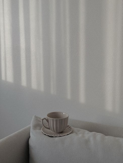 A serene still life image featuring a cup on a cushion in soft natural light.