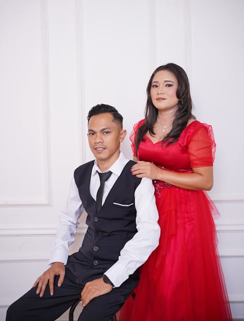 Woman in Red Dress Posing with Man in Shirt with Vest