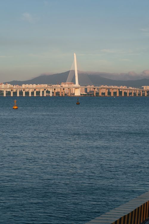 Free A modern cable-stayed bridge spans across a calm sea, enhancing coastal beauty. Stock Photo