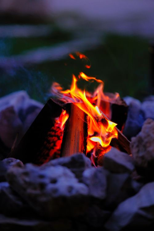 Free A close-up shot of a burning campfire in Tobermory, Ontario, creating a warm and inviting night atmosphere. Stock Photo