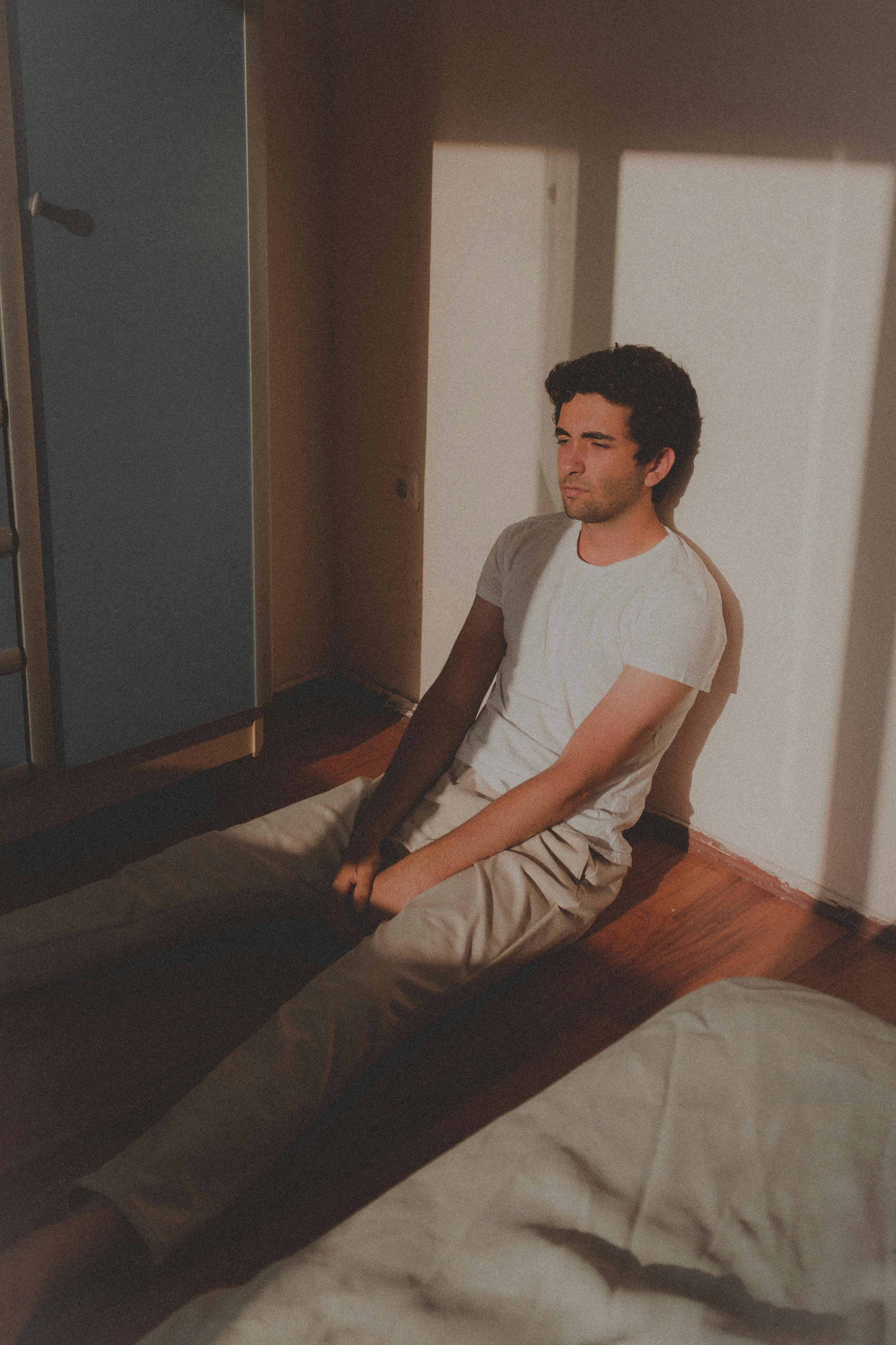 Gratuit Bărbat în Tricou Așezat Pe Podea Fotografie de stoc