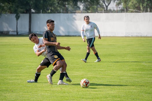 Players in an intense football match, showcasing teamwork and skill on the green field.