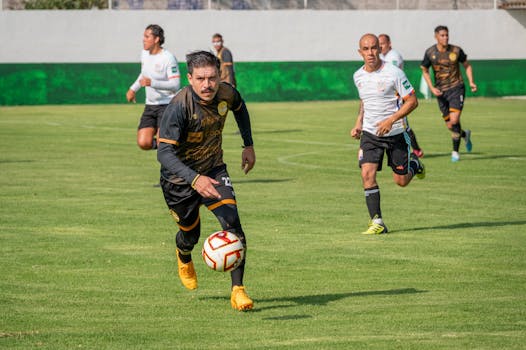Dynamic soccer match showcasing players in action on a bright green field under clear skies.