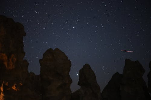 Free Silhouetted Rock Formations against a Starry Night Sky  Stock Photo