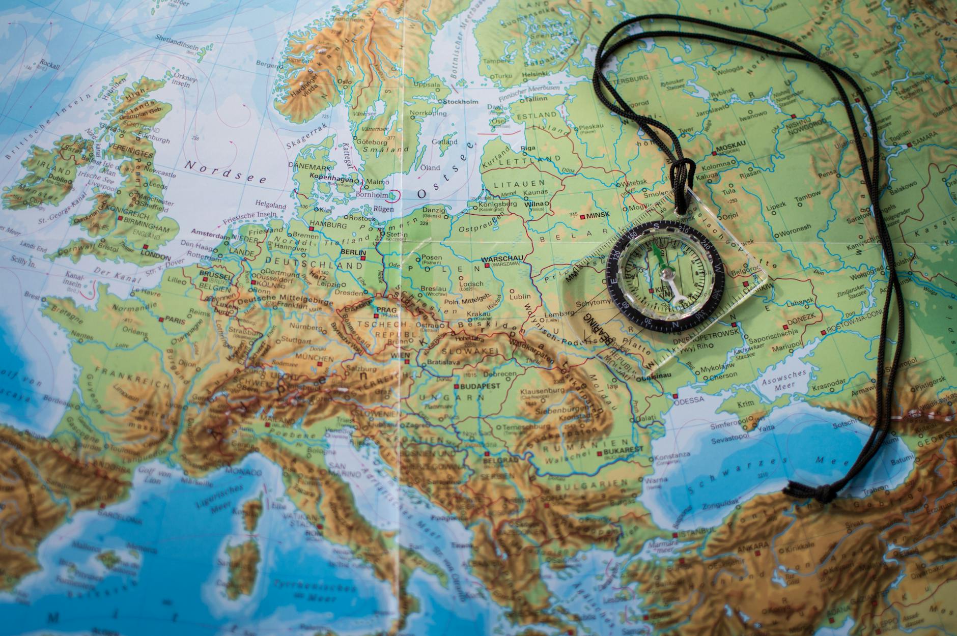 A compass placed on a detailed map of Europe showcasing travel and exploration themes.