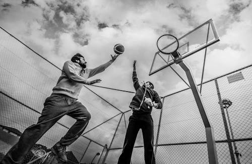 Men Playing Basketball in Black and White