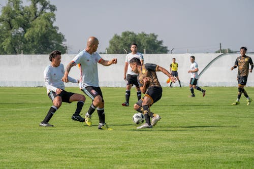 Men Playing Football on Grass