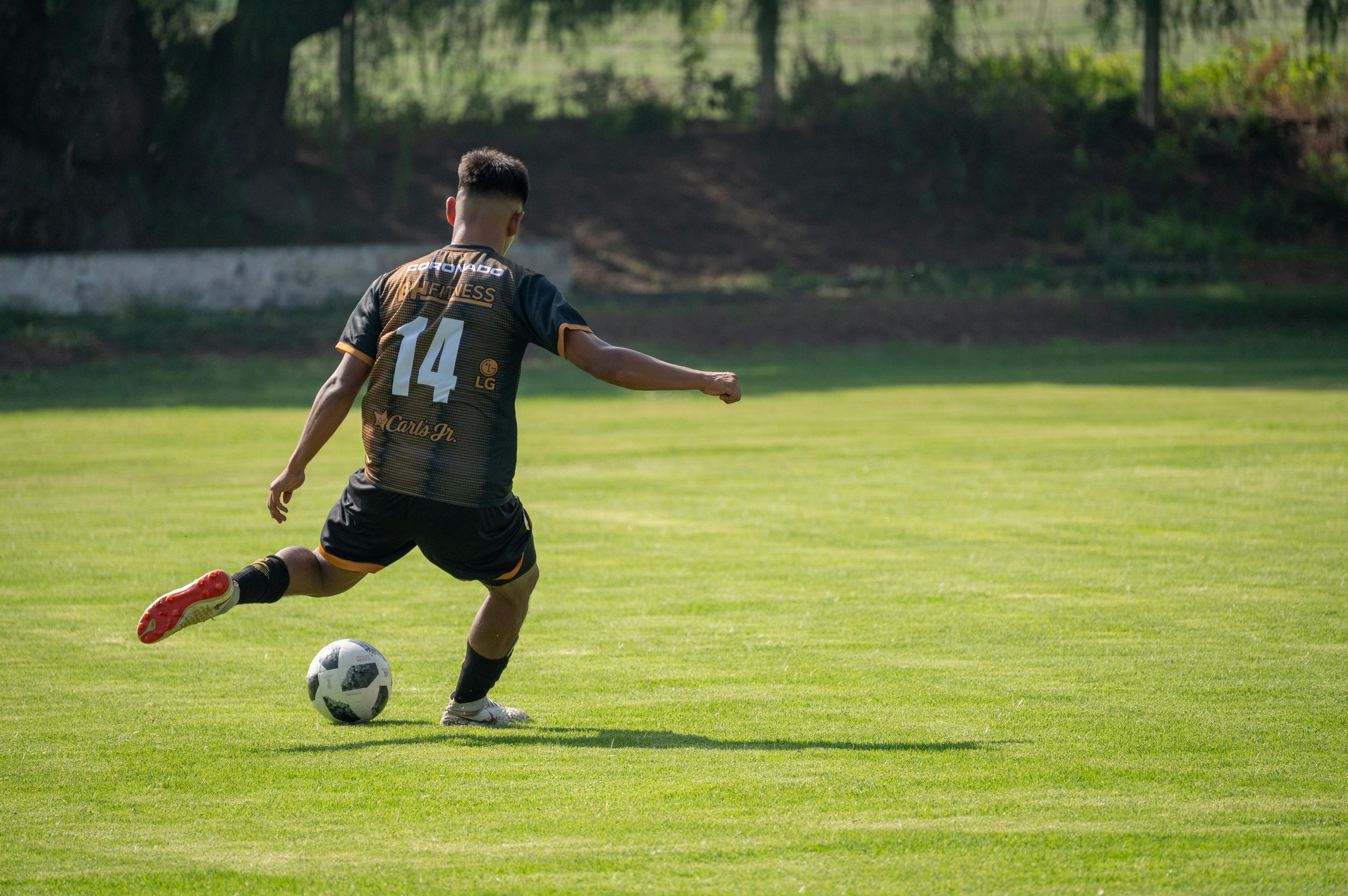 soccer kicking a football on a pitch