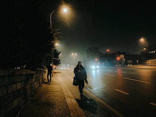 Man Walking in City at Night