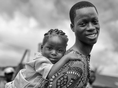 Parent Carrying a Small Child on Back