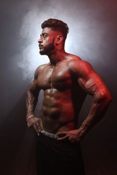 Athletic male model posing in studio lighting, showcasing muscular physique and fitness goals.