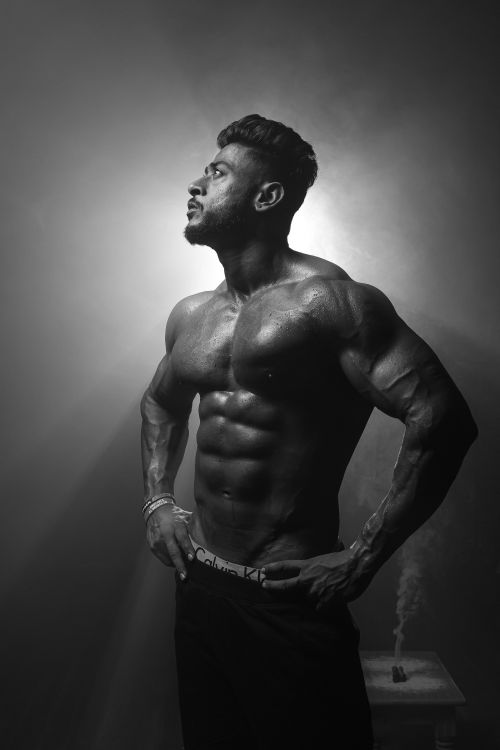Free Striking black and white portrait highlighting a muscular man's physique in dramatic lighting. Stock Photo