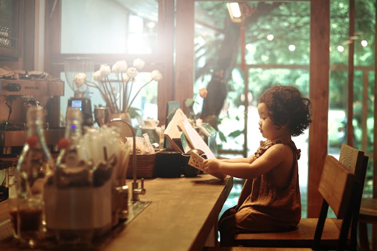 Young Girl Reading In A Cafe