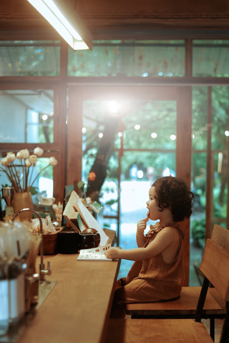 Little Girl Sitting At The Counter