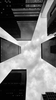 Black and white photo of Toronto skyscrapers framing a cloudy sky.