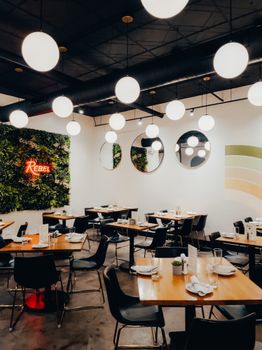 Stylish restaurant interior showcasing modern furniture, wall decor, and spherical lighting.