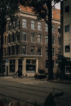 A classic brick building in an old town setting with street view and cyclist passing by.