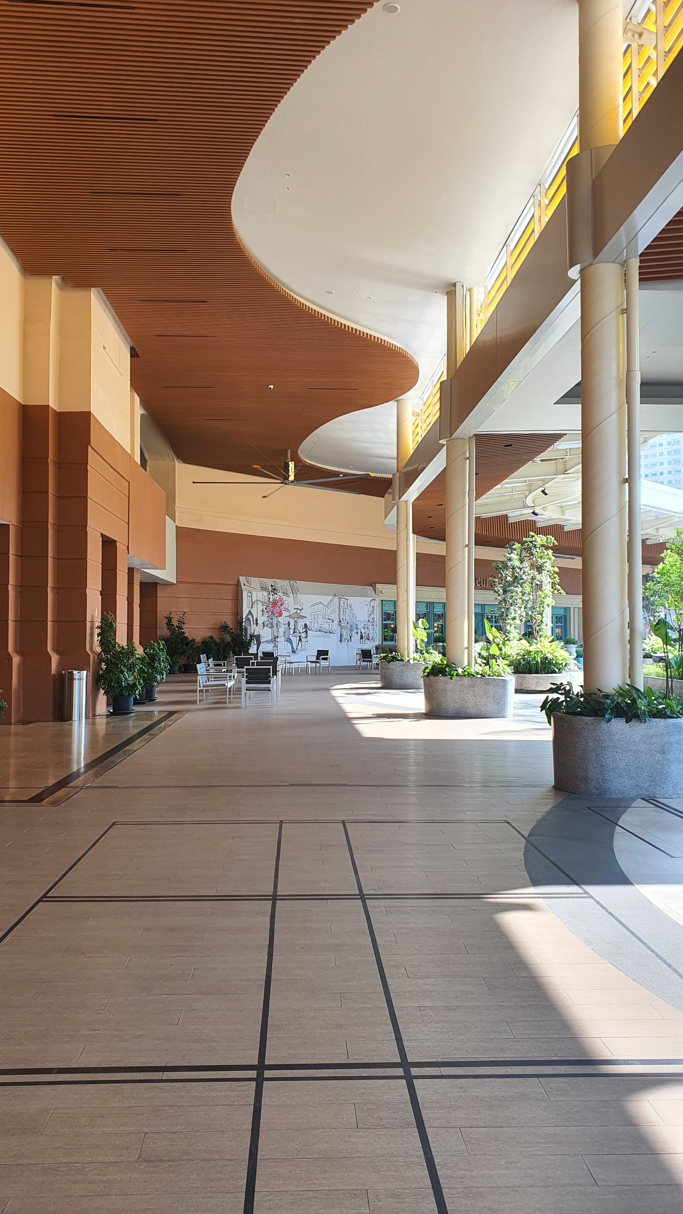 Elegant interior with curved ceiling design, columns, and natural light.