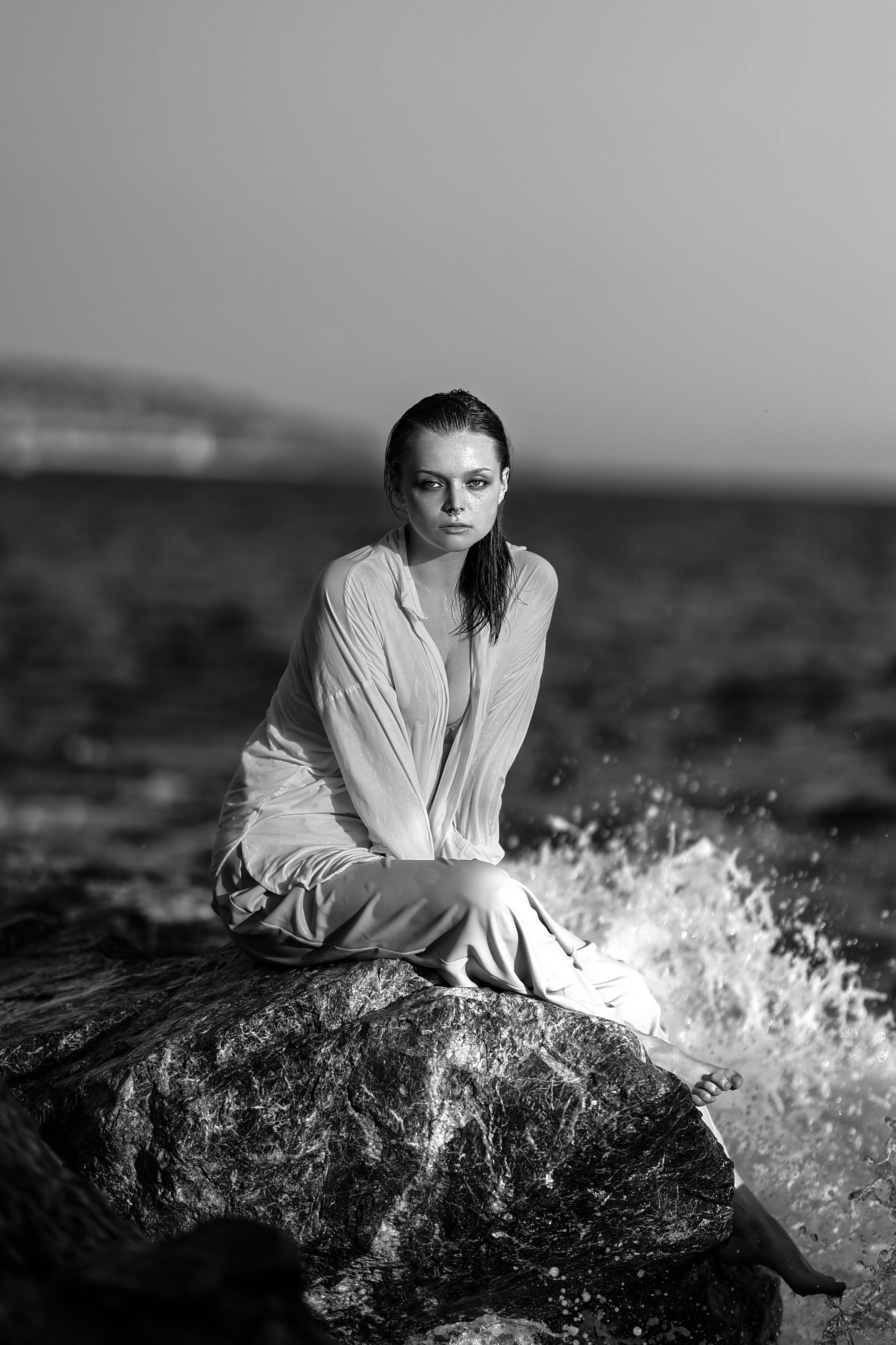 Woman Sitting on a Rock at the Edge of a Sea · Free Stock Photo