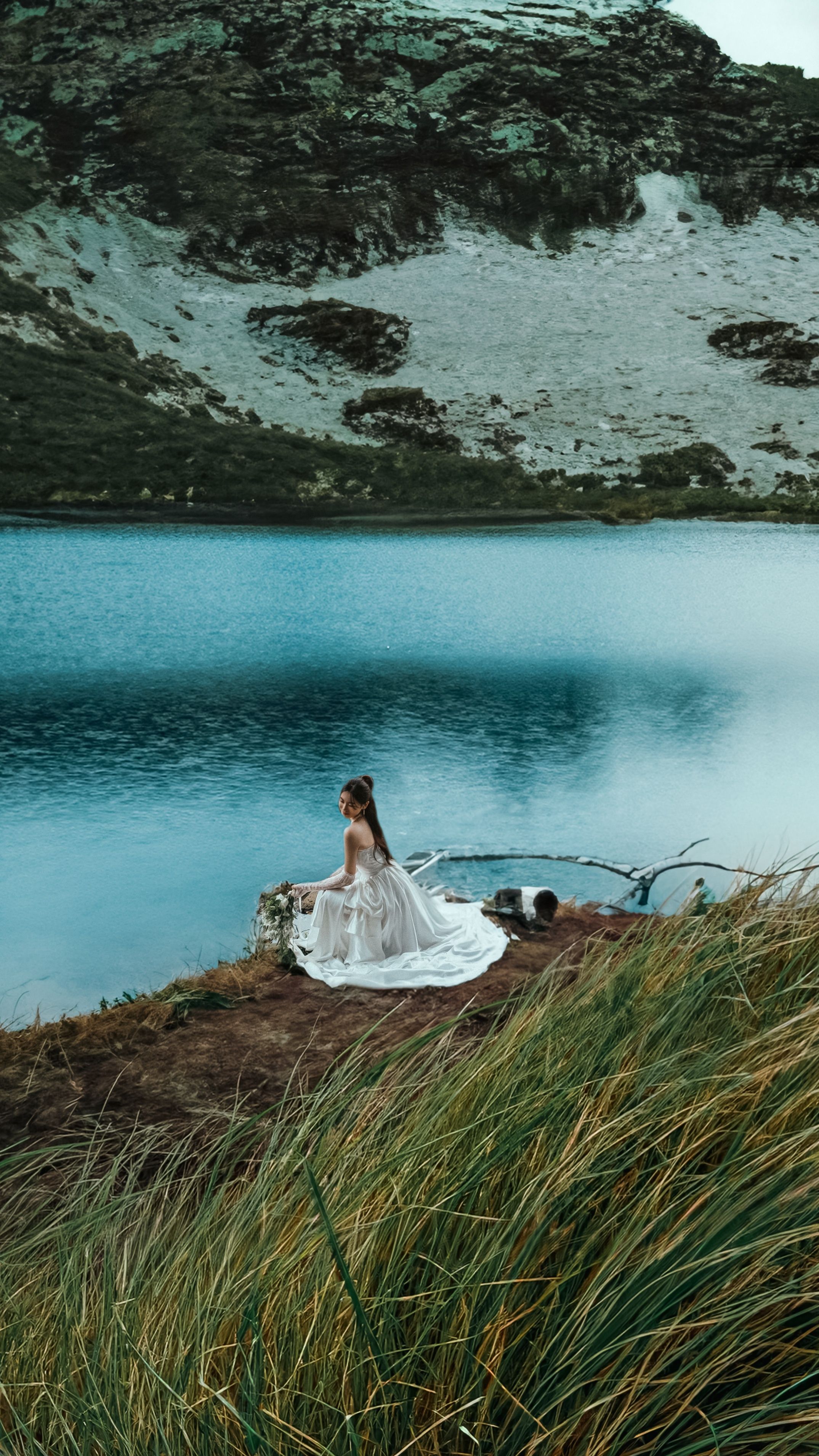 Woman in a White Dress Sitting by the Body of Water in the Valley ...