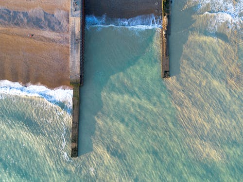 Piers on Sand Beach in Sea