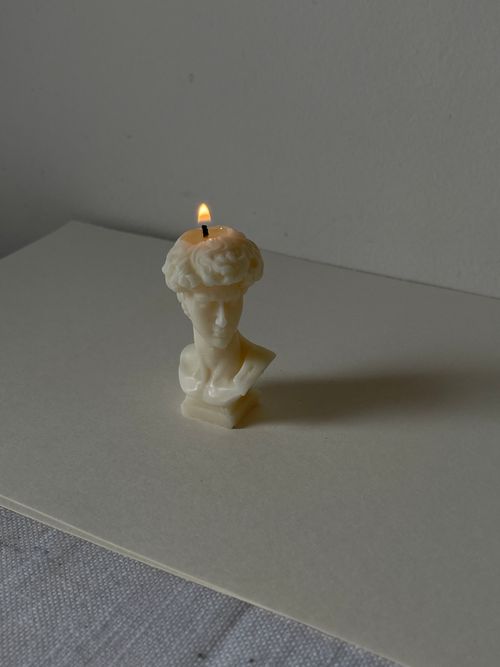 Free Elegant minimalist sculpture candle with a gentle burning flame. Stock Photo