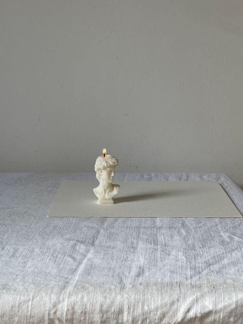 Free A contemporary bust-shaped candle burning elegantly in a minimalist setting, embodying art and modern decor. Stock Photo