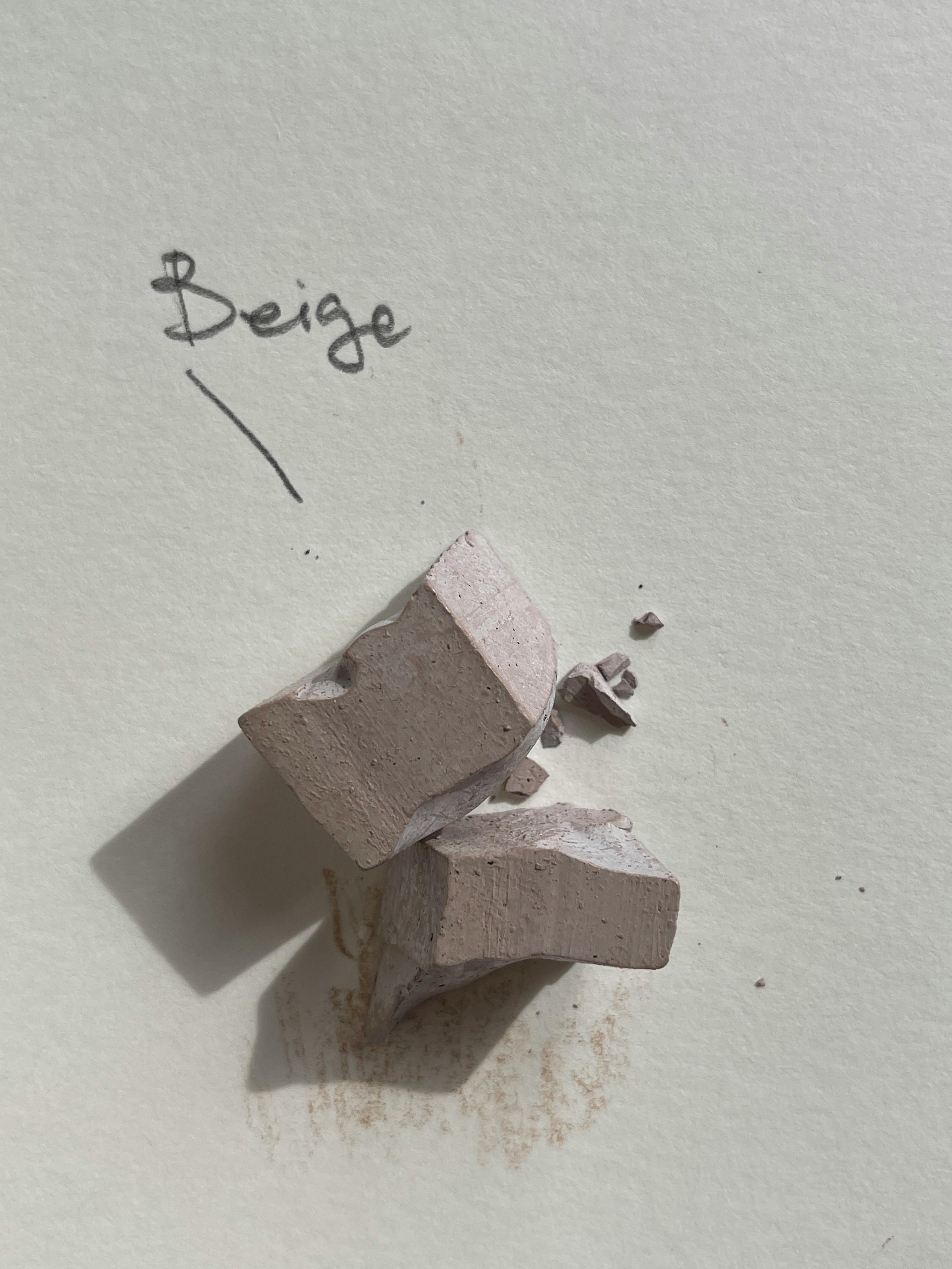 Close-up of beige chalk pieces on paper with a handwritten label 'Beige' highlighting texture and color.