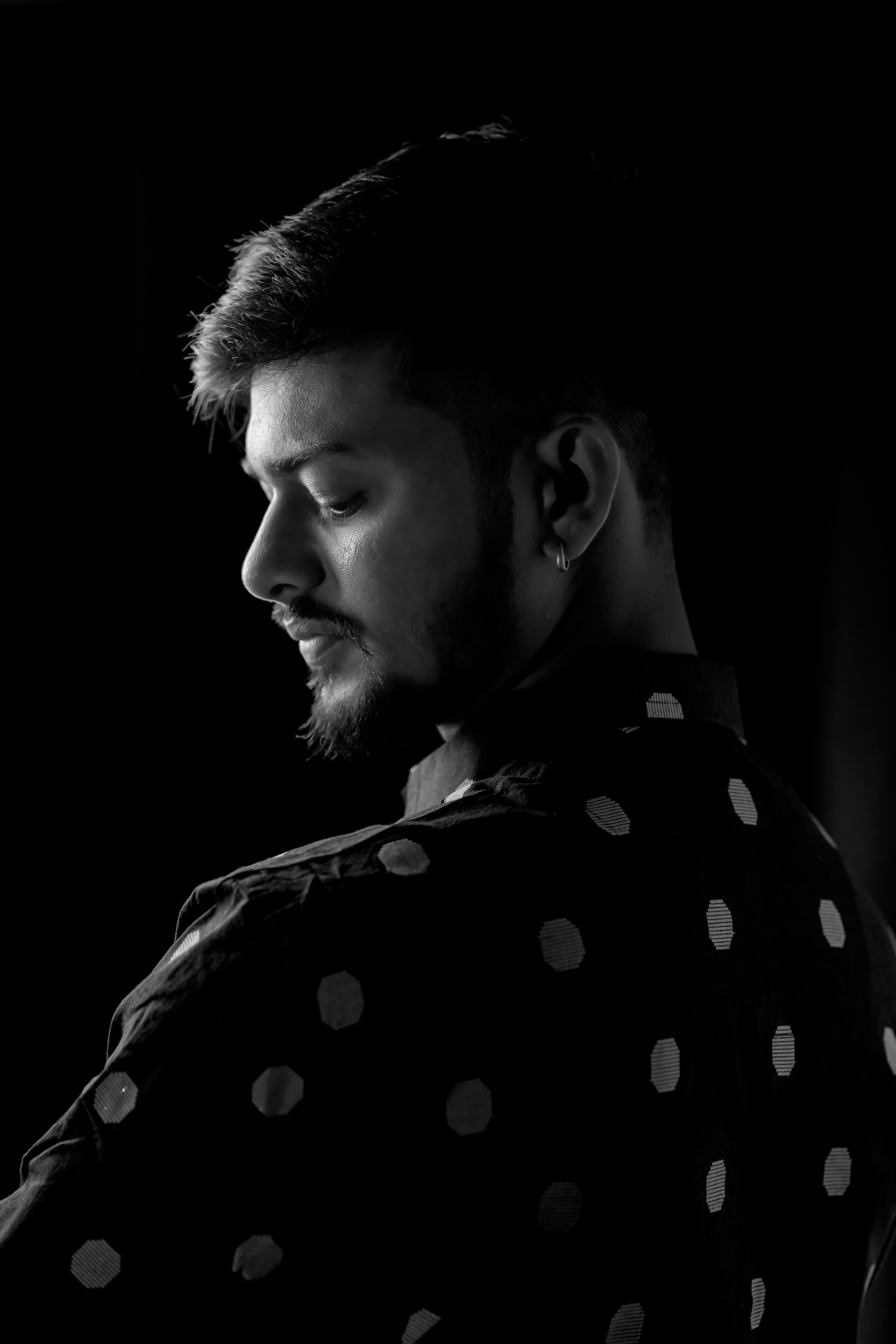 Free Black and white portrait of a man in a dotted shirt with artistic lighting. Stock Photo
