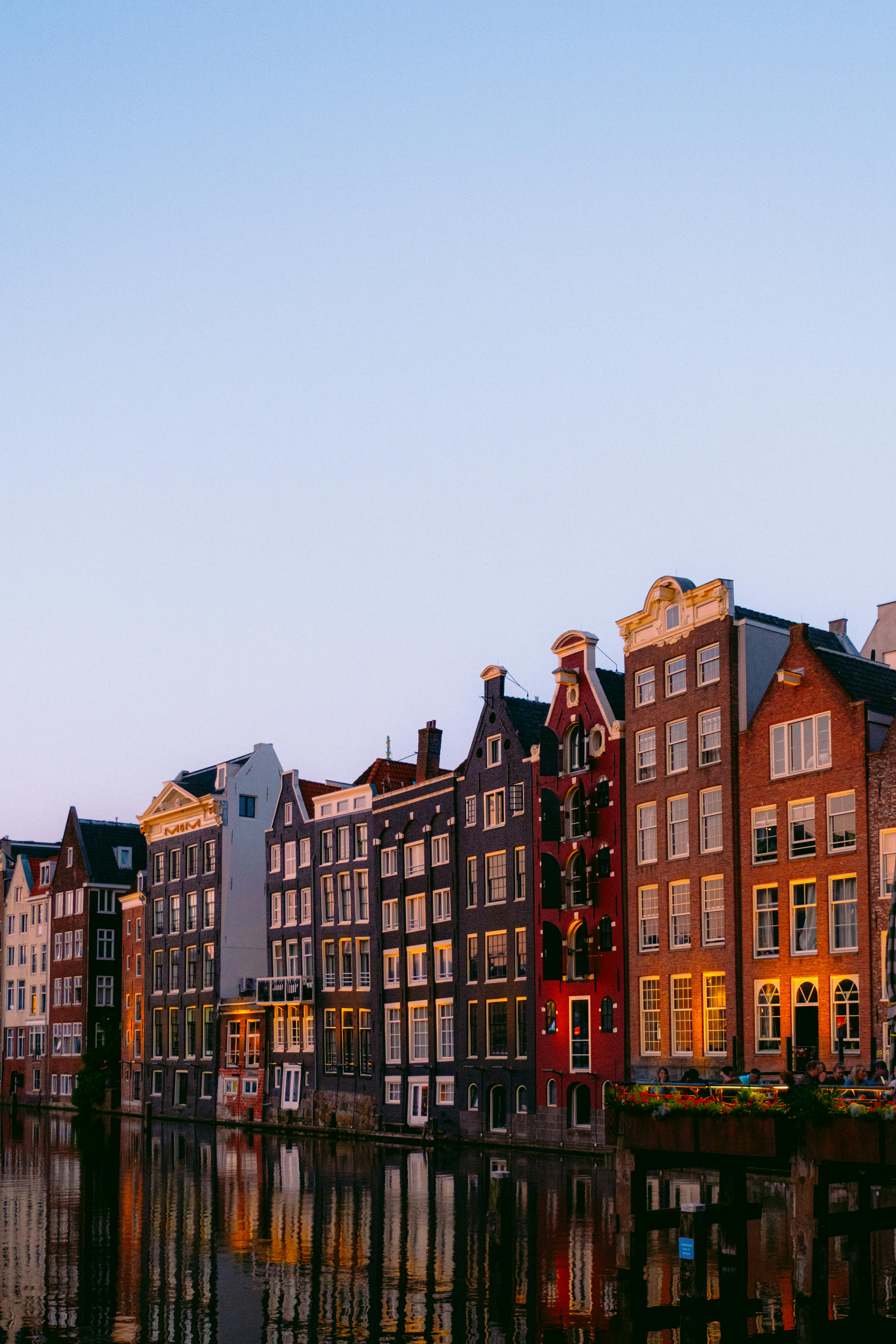 Picturesque Amsterdam canal lined with iconic traditional houses during a serene sunset.